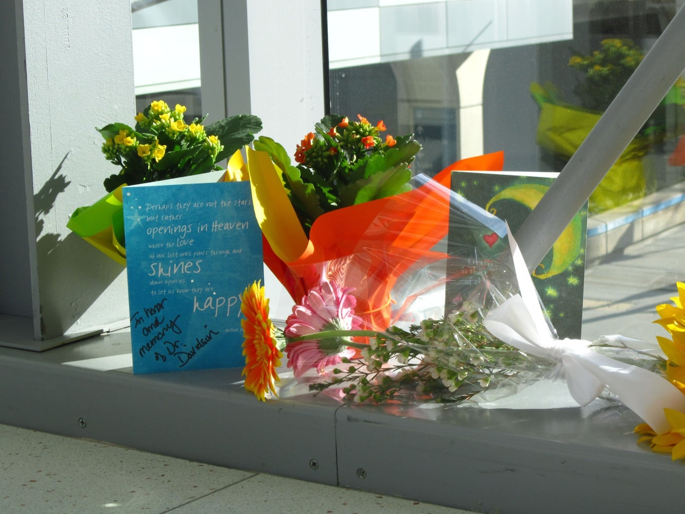 Flowers and cards on the skywalk between Brigham and Women’s Hospital’s main building and Shapiro building commemorate Wednesday the death of Harvard Medical School assistant professor Michael J. Davidson, who died Tuesday after he was shot on the second floor of the Shapiro building. Business appeared to proceed as usual at the Brigham on Wednesday morning, with no visibly increased security presence and no police presence. 