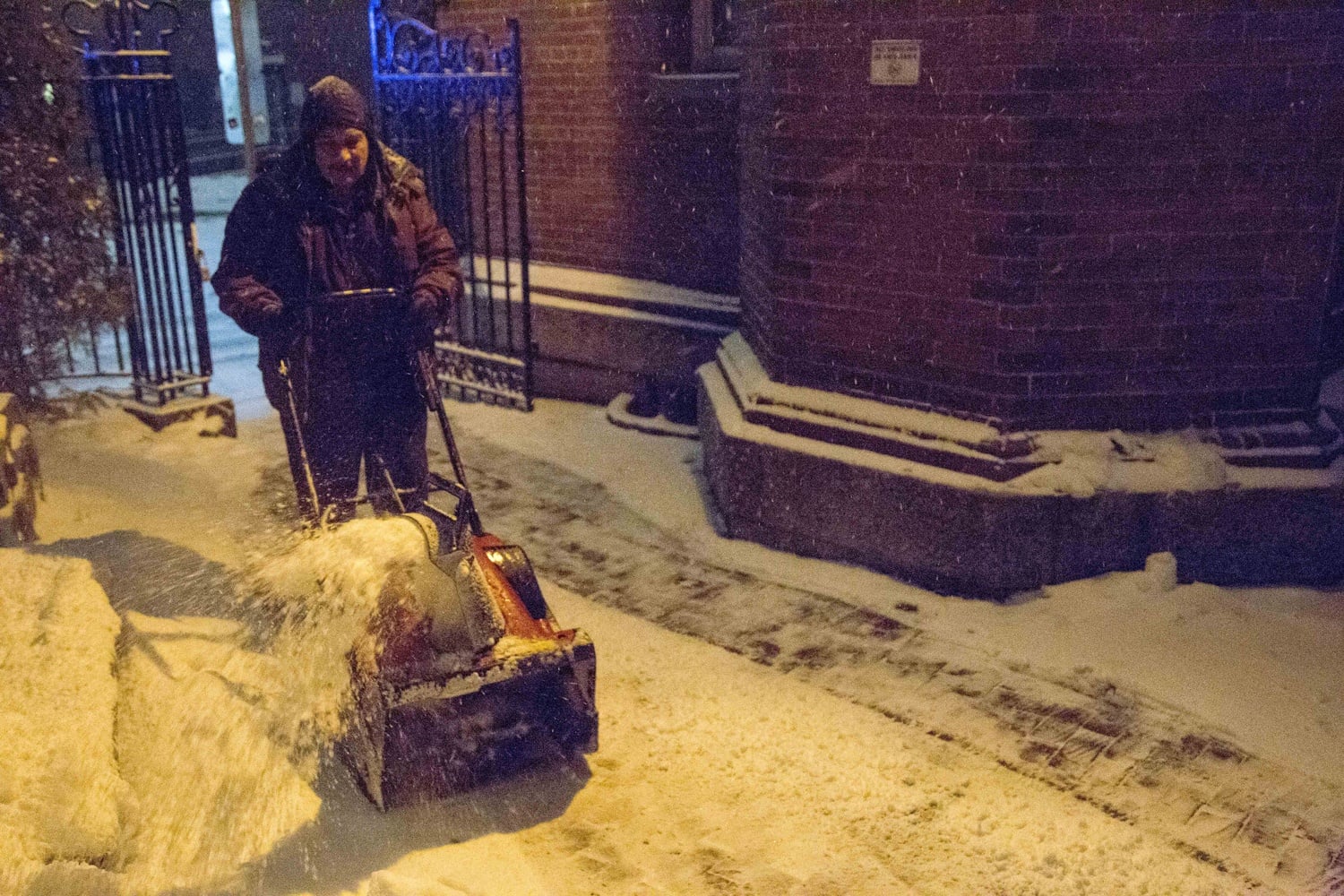 Harvard Campus Services custodian Ramon Casas plows snow outside Adams House on Monday evening. He will spend Monday night on campus with other staff members as a blizzard descends on the Boston area.