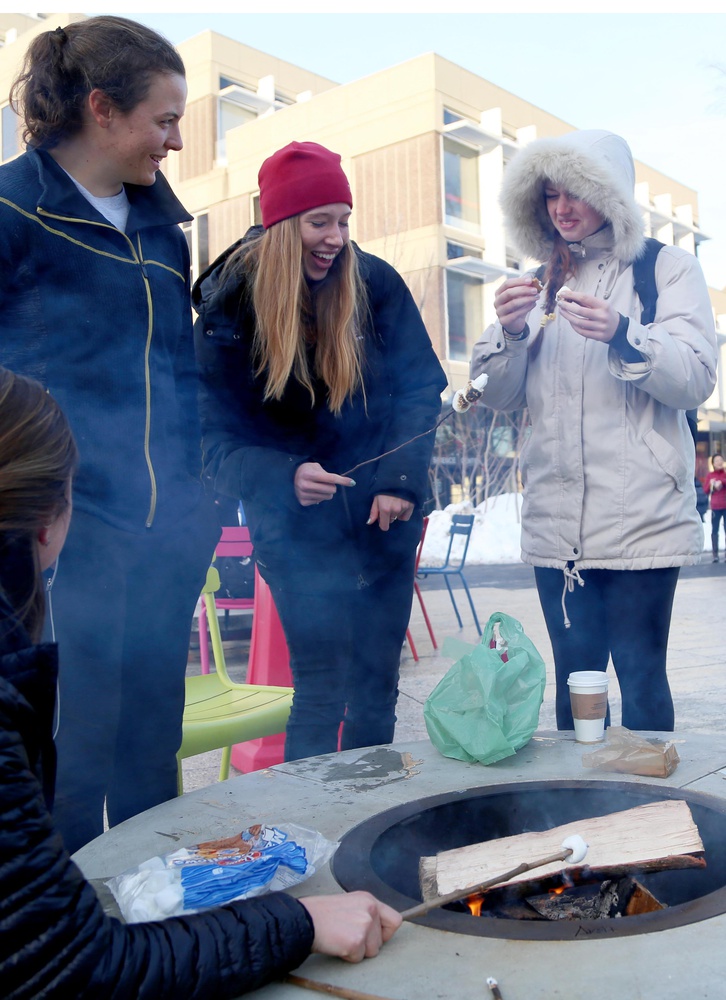 From left, Maya M. Learned '18, Katherine R. Playfair '18, Kathleen D. Malloch '18 roast marshmallows at fire pits outside the Science Center on Thursday afternoon. The fire pits were recently installed as part of a University initiative to increase common spaces on campus.