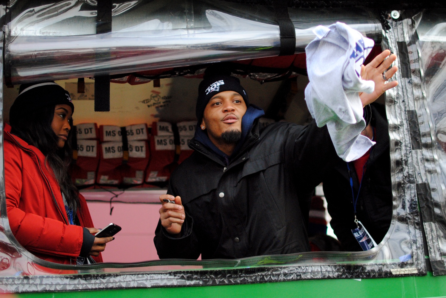 Patrick C. Chung, a strong safety for the Patriots, throws an autographed shirt back to a  fan during the Super Bowl parade in Boston on Wednesday.