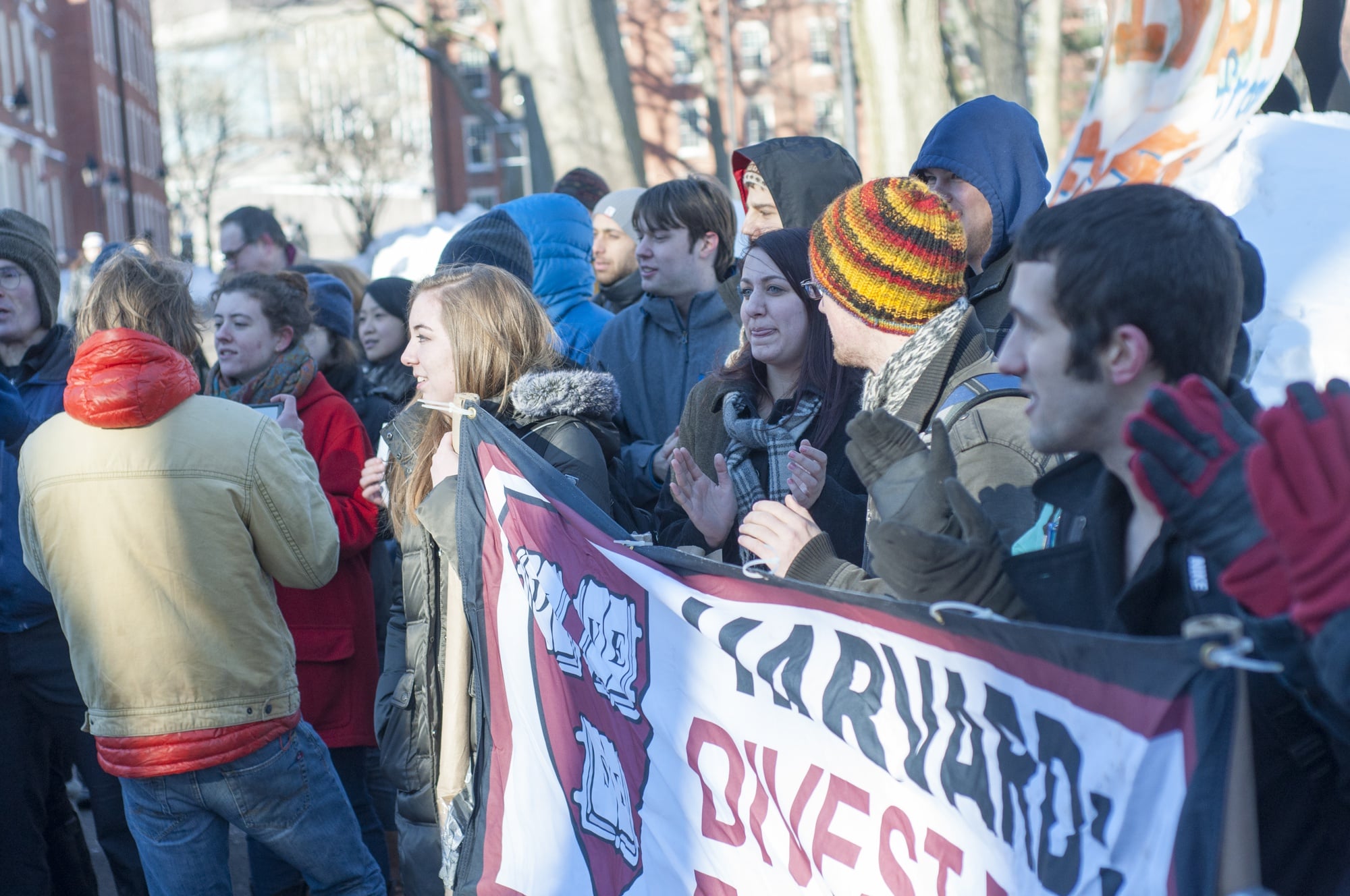 Divest Harvard students held a sign outside Massachusetts Hall on Friday, Feb. 13 as part of Global Divestment Day.
