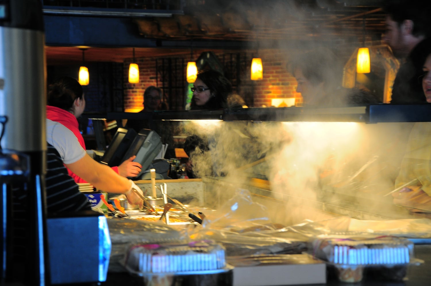 Smoke rises as employees at Felipe's quickly fill burrito orders for customers. Offering a delicious range of Mexican food products such as quesadillas and tacos, Felipe's burritos are one of the most popular items on the menu.