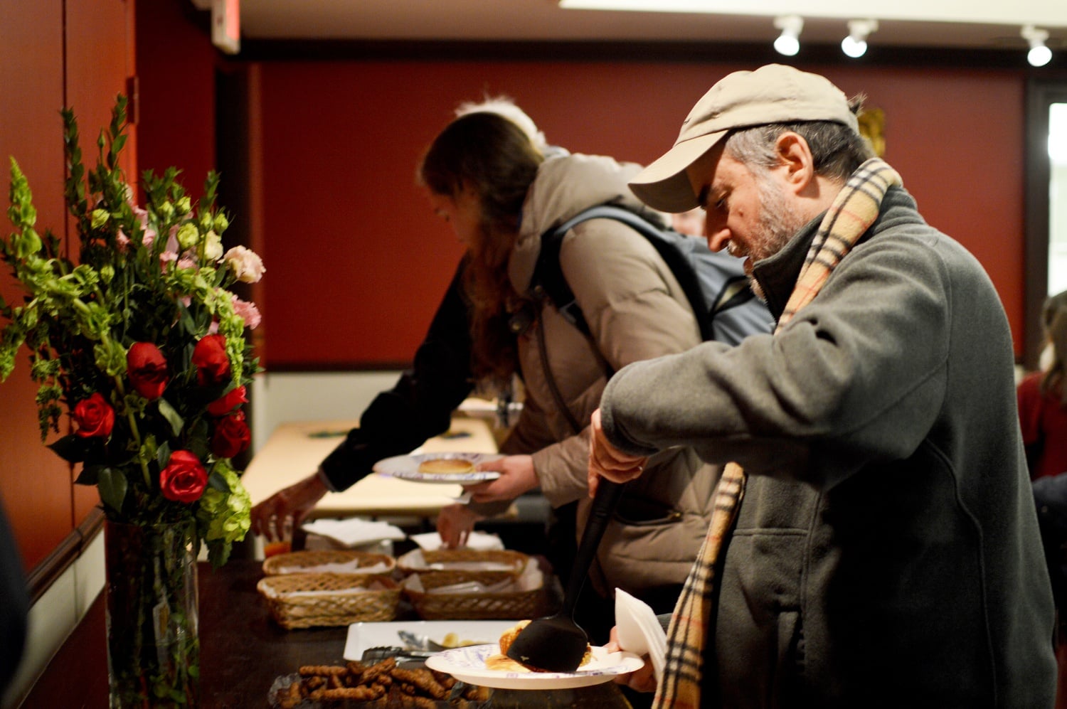 A patron takes a pancake at Memorial Church Wednesday evening to commemorate Shrove Tuesday and the start of Lent today. The organizers also collected used hats, gloves, and scarves for the Women’s Lunch Place, an organization where women who experience poverty or homelessness gather and get some of their basic needs met.
