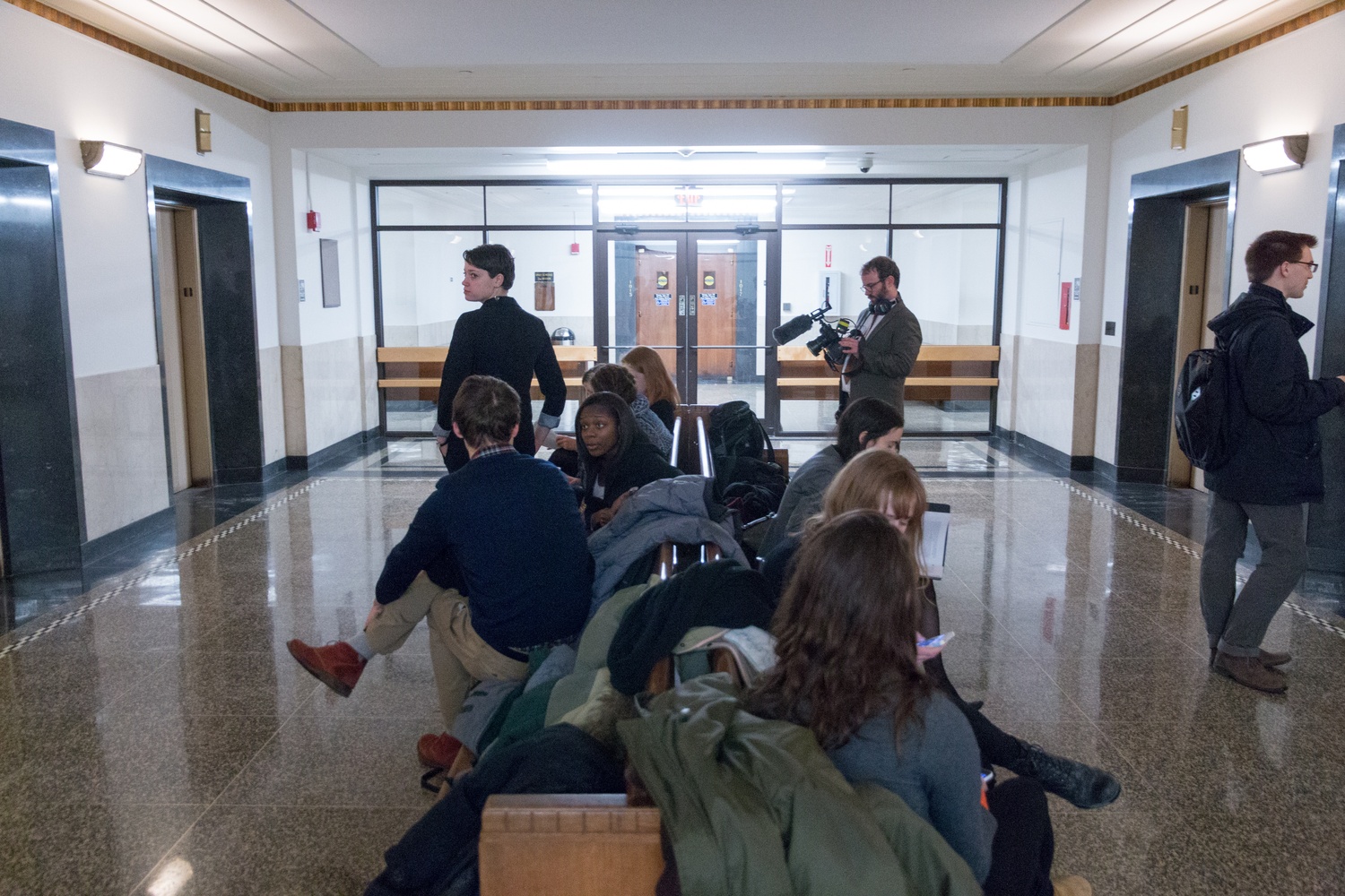 Members of Divest Harvard gather in the elevator lobby just outside a Suffolk County courtroom Friday.