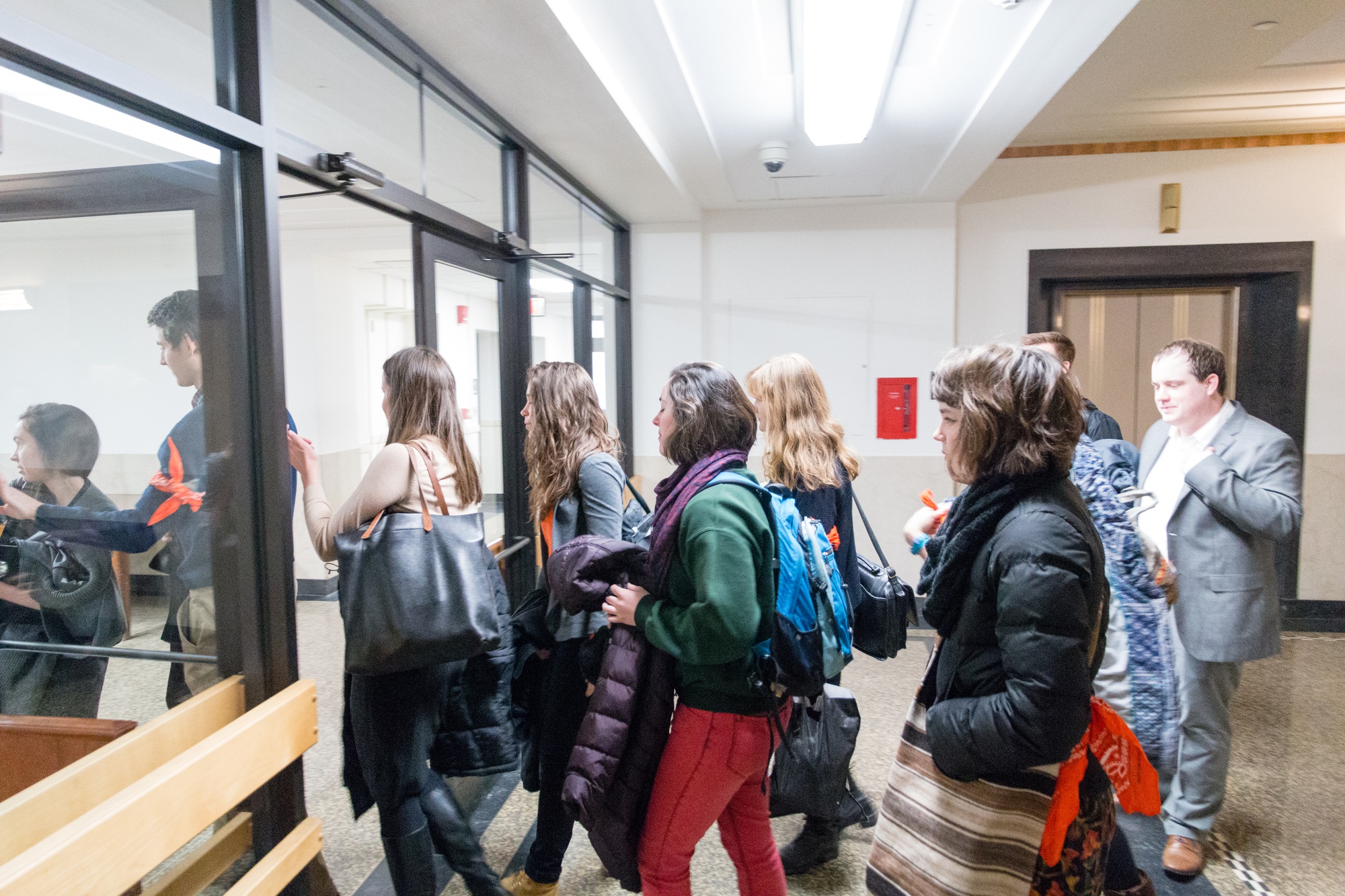 Member of Divest Harvard file out of the elevator lobby toward the Suffolk County courtroom Friday.