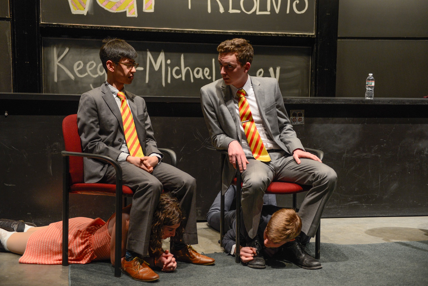 Ezra H. Stoller '15, Kira S. Brenner '18, Mike A. Skerrett '18, and William J. Deuschle '18 act out al sketch in which children must be stowed under seats in an airplane. 