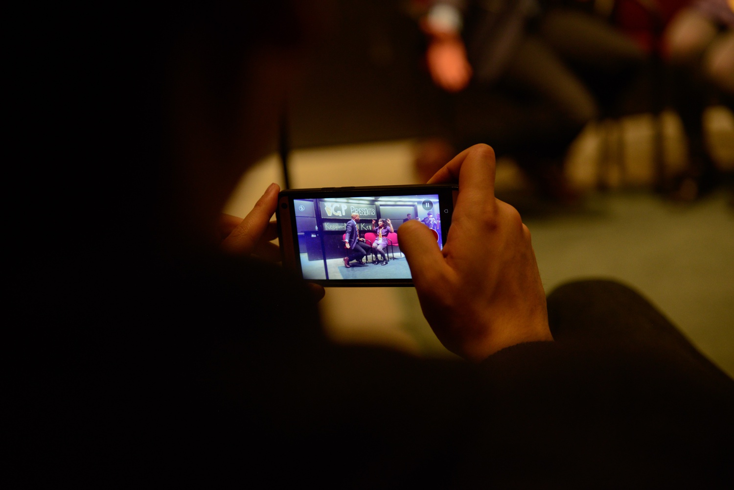 An audience member videotapes Keegan-Michael Key and Karen Chee '17.