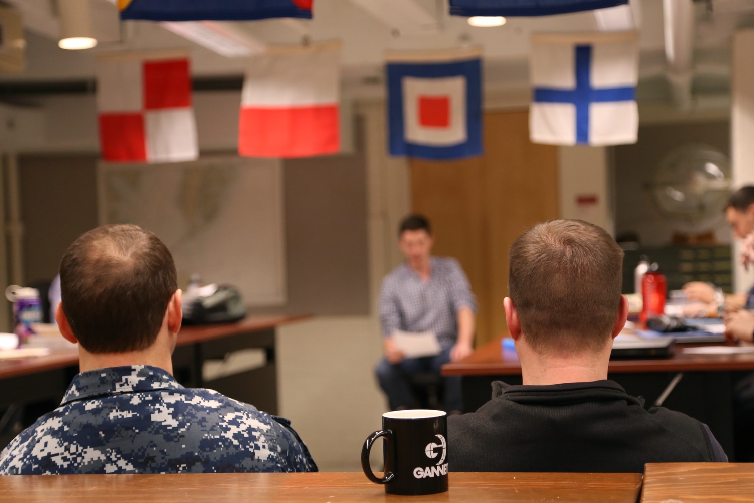 ROTC midshipmen and Marine options give presentations during a naval history class at MIT. Students in Naval ROTC usually take a course on military science each semester.
