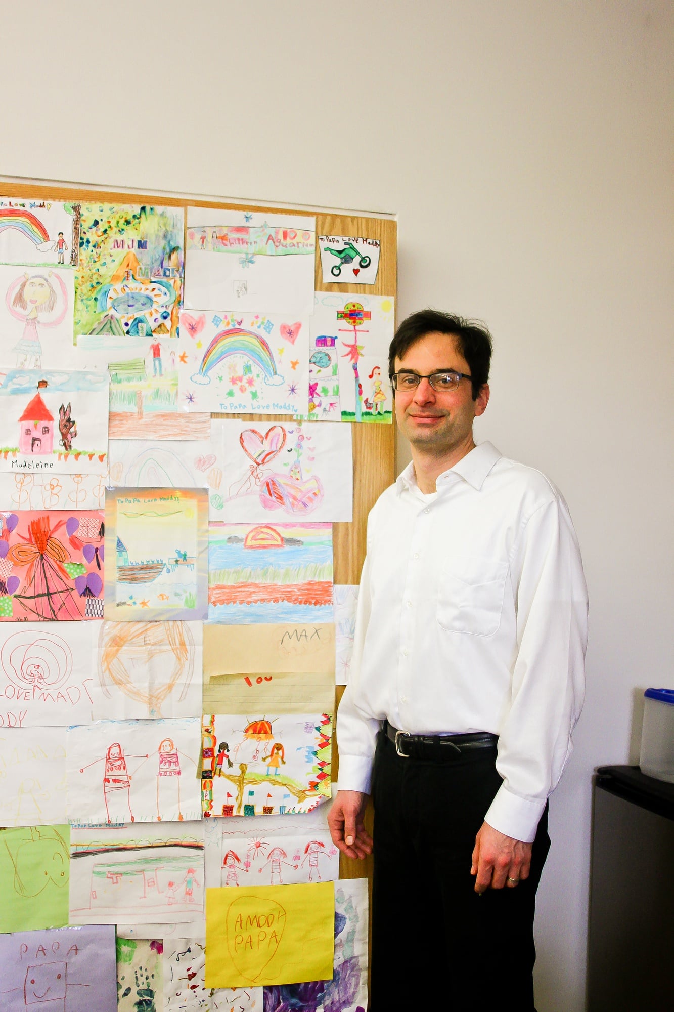 Philosophy professor Jeffrey K. McDonough pictured here next to the door to his office, which is covered completely in artwork by his two children.
