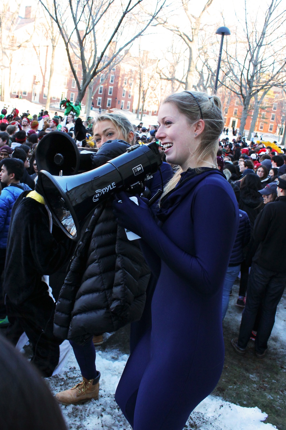 Students dressed in blue leotards find a prime location near the John Harvard to cheer. Upperclassmen stormed Harvard Yard on Thursday morning to start off Housing Day festivities.
