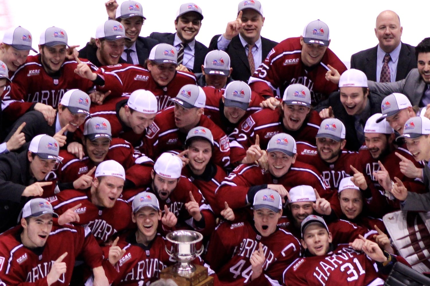 The Harvard men's ice hockey team celebrates with the Whitelaw Cup after defeating Colgate, 4-2, in the 2015 ECAC tournament final in Lake Placid, N.Y.