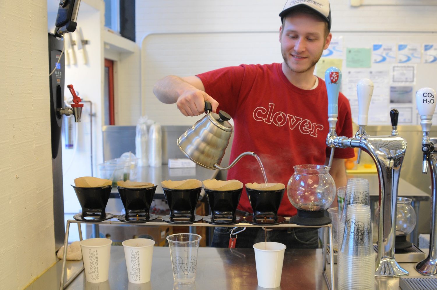 On a Thursday afternoon a Clover employee pours hot water into paper funnels to make coffee. Clover coffee is a campus favorite.