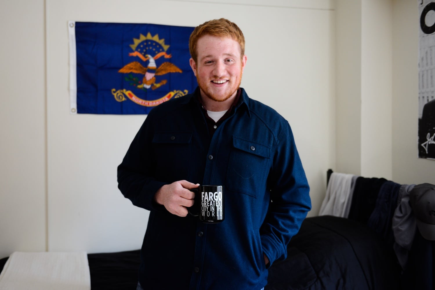Mark S. Staples '17 poses with a mug and flag from his home state of North Dakota. Staples is one of few students from the region.