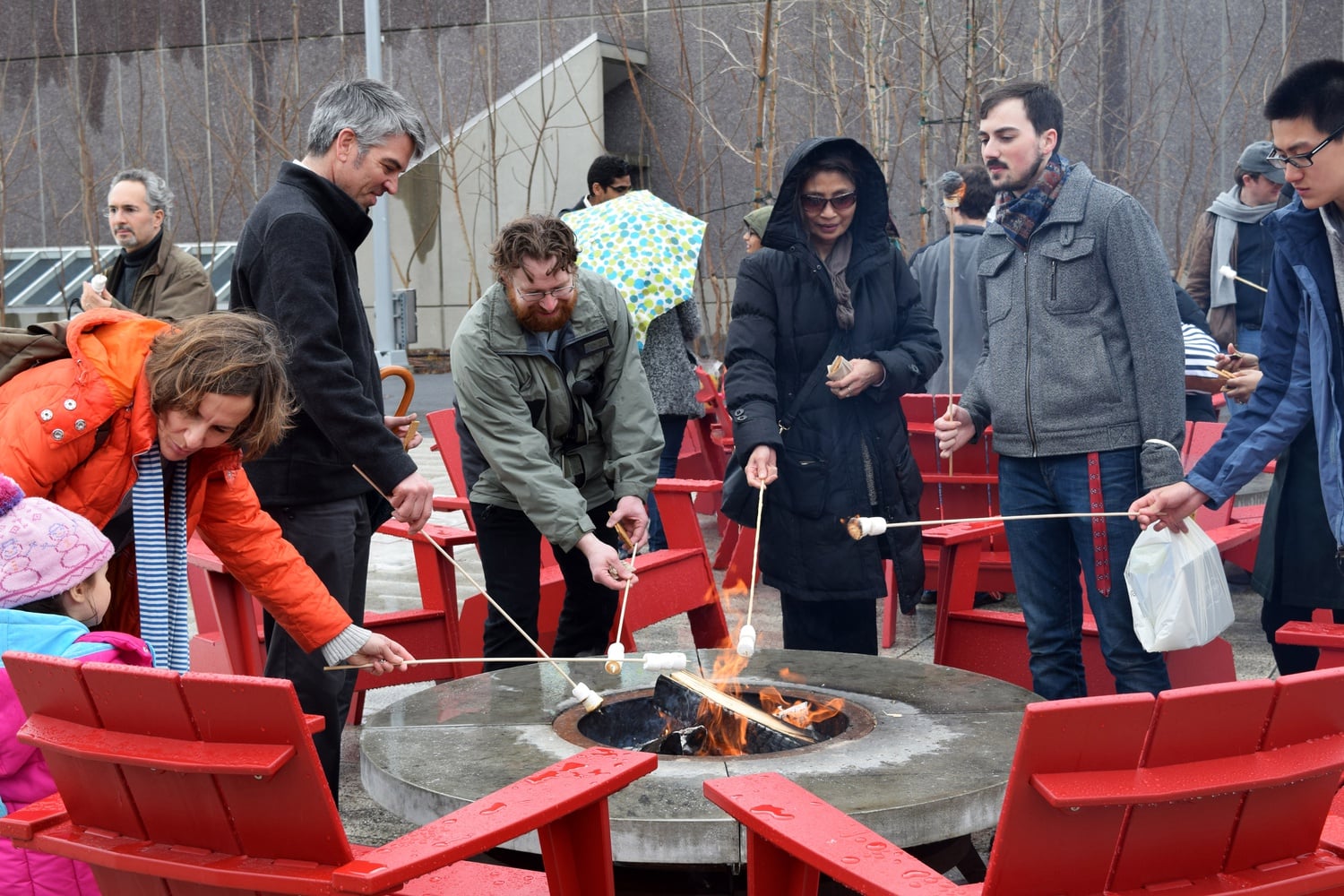 A group of people roast marshmallows as part of President Drew G. Faust's event to welcome spring on Wednesday afternoon. Miguel Hernandez who works for the Harvard Faculty Club, says the event is "a celebration of spring" where they "are going to give all the flowers away and there is hot chocolate and marshmallows."