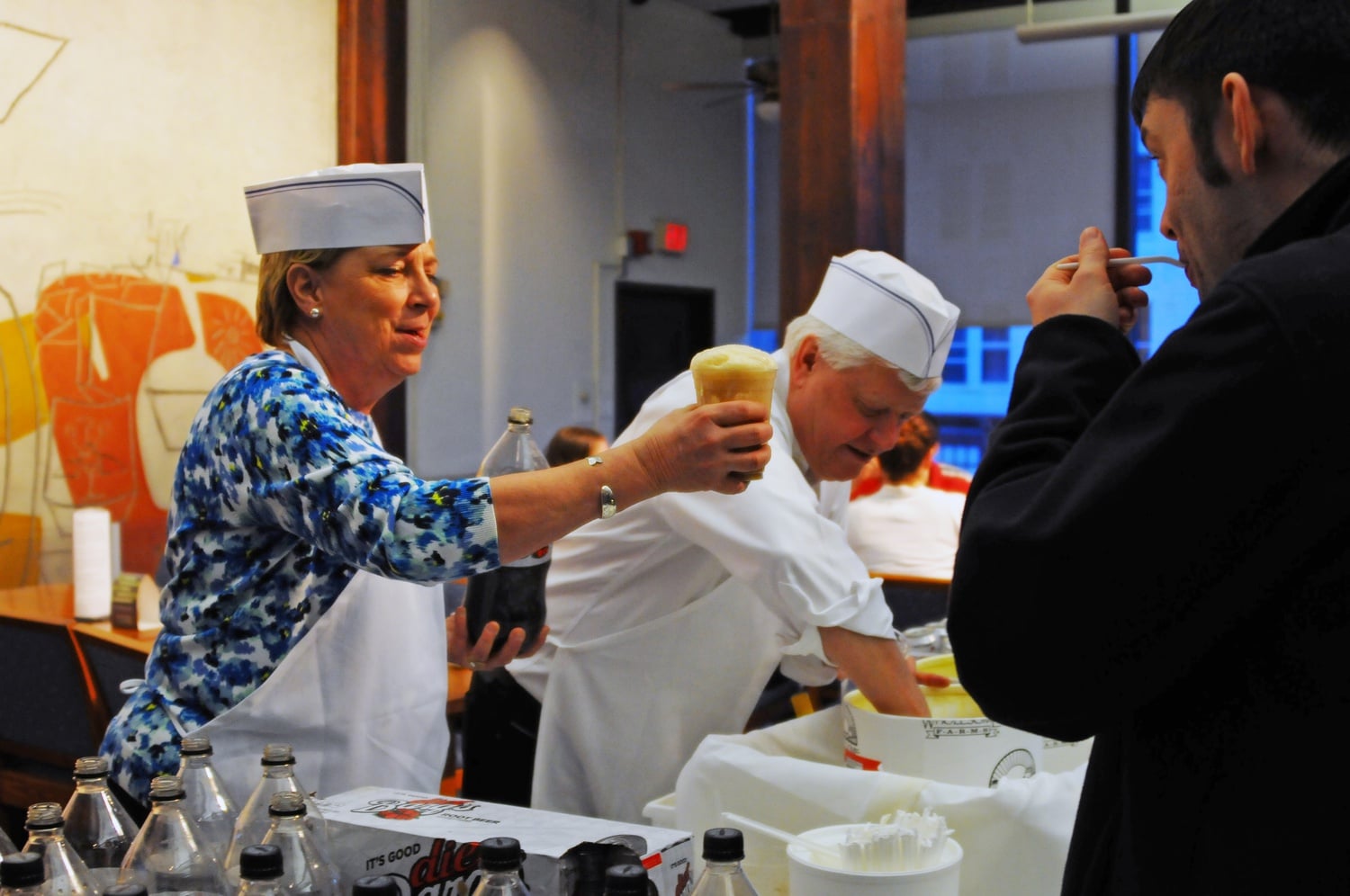 Quincy Housemasters Lee and Deborah J. Gehrke serve cake and root beer floats in '60s diner apparel to celebrate Deborah's birthday, which is this Friday. The treats were served during community dinner in Quincy on Thursday evening.