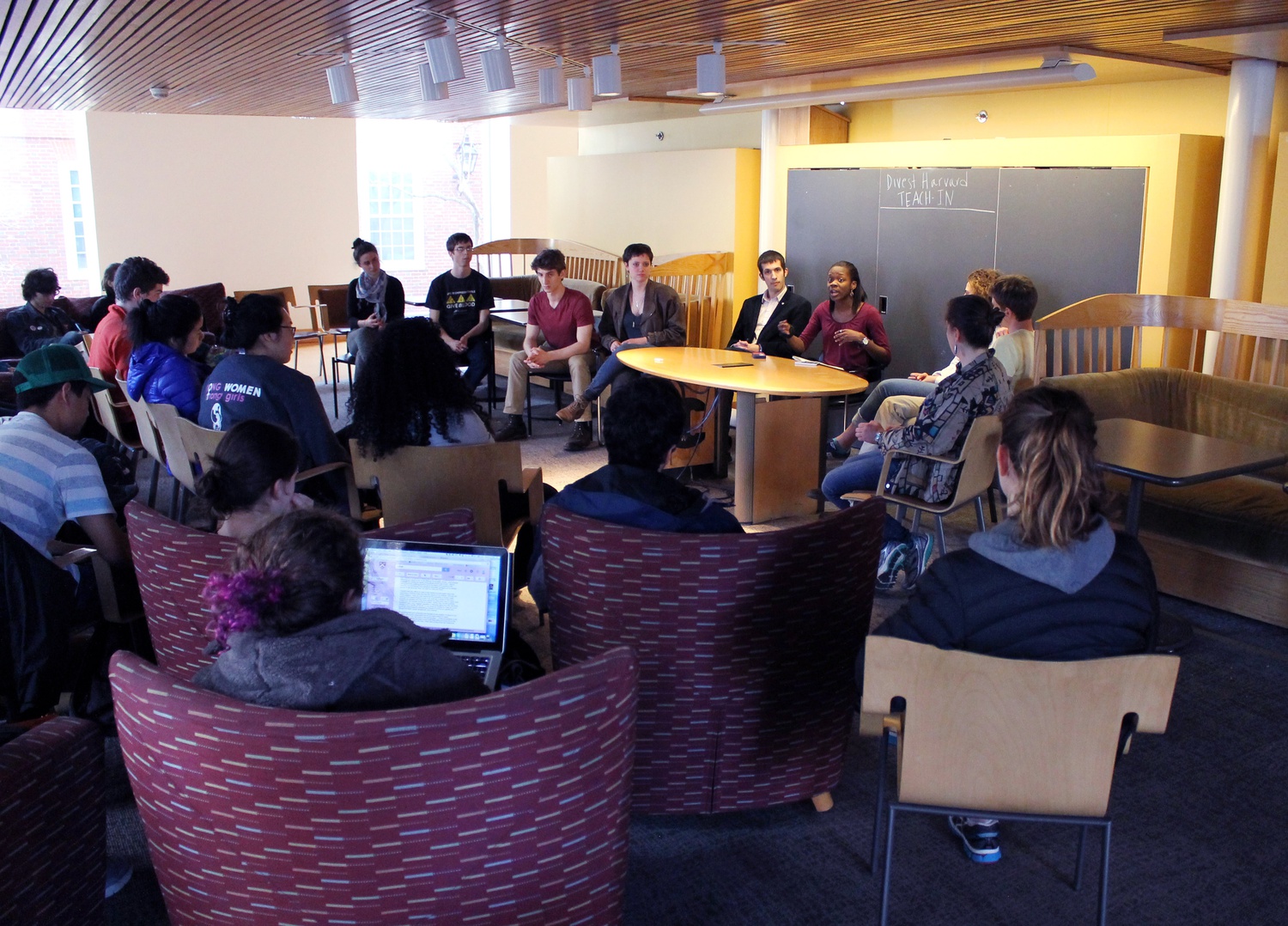 Members of Divest Harvard speak about the history of the group, which began with 3 students and has held active peaceful protests, fasts, and sit-ins since its conception 3 years ago in Ticknor Lounge on Monday evening. 