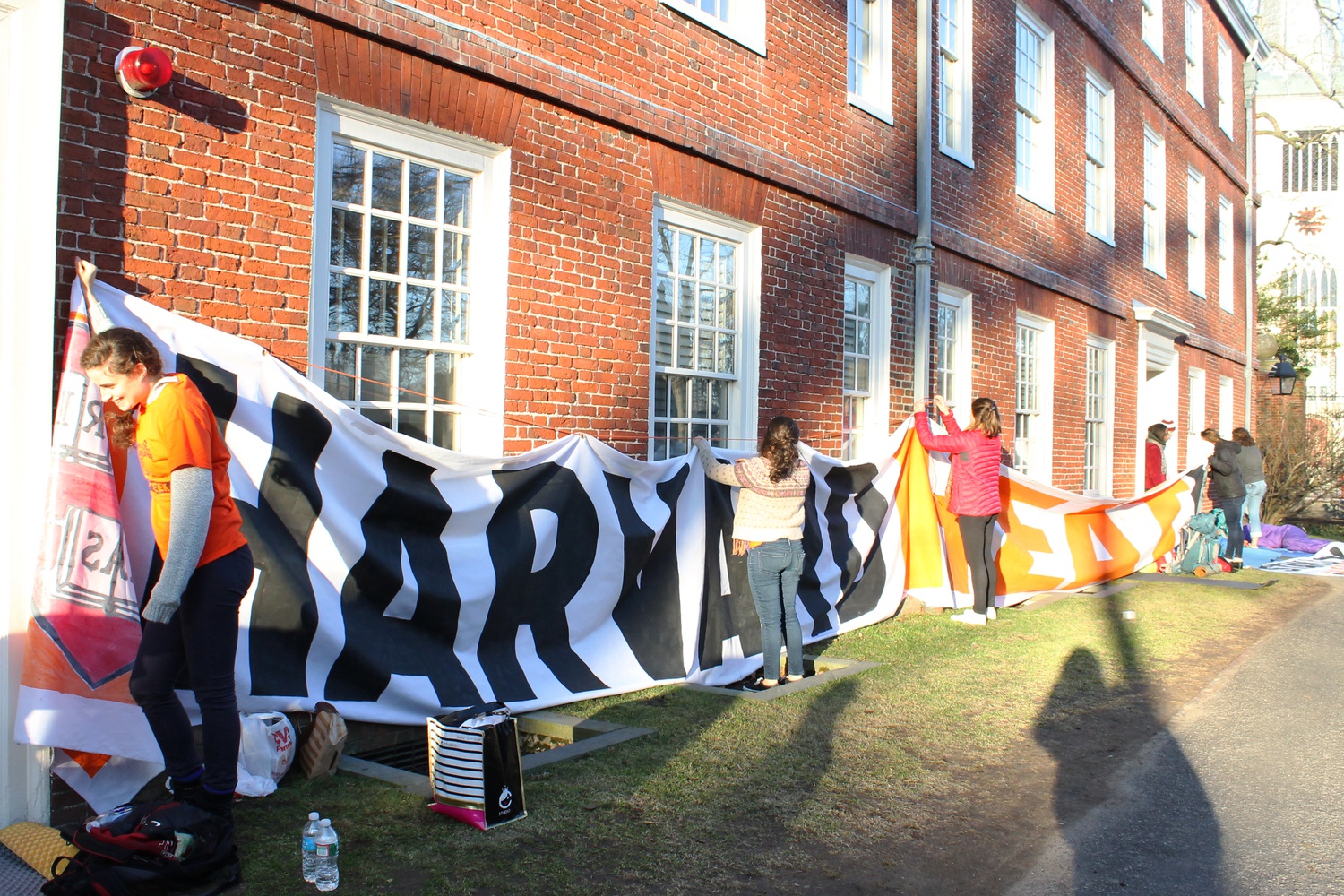 Activists of "Harvard Heat Week" put up a poster on the side of Massachusetts Hall on Monday morning. 