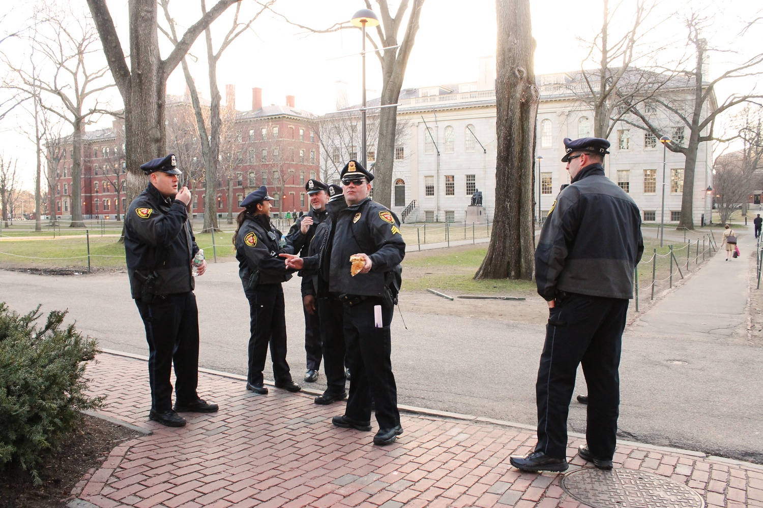  HUPD officers greet each other as they change shifts on Monday morning outside of Massachusetts Hall where "Harvard Heat Week" activists had been sleeping. 
