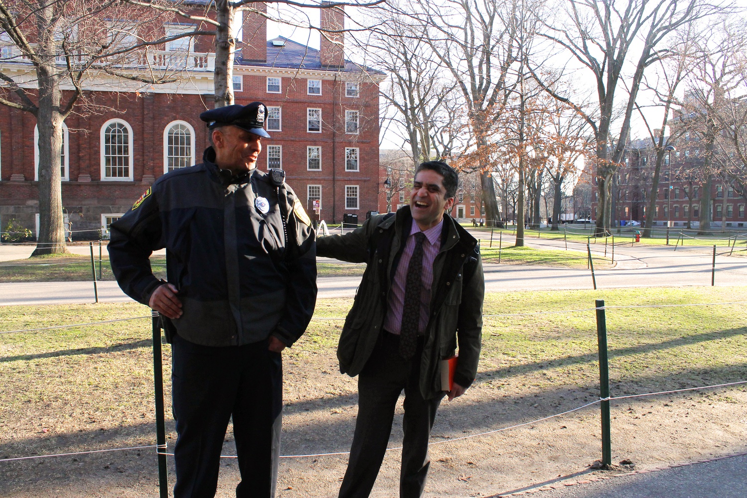 Dean of the College Rakesh Khurana converses with a HUPD officer on Monday morning outside of Massachusetts Hall. 