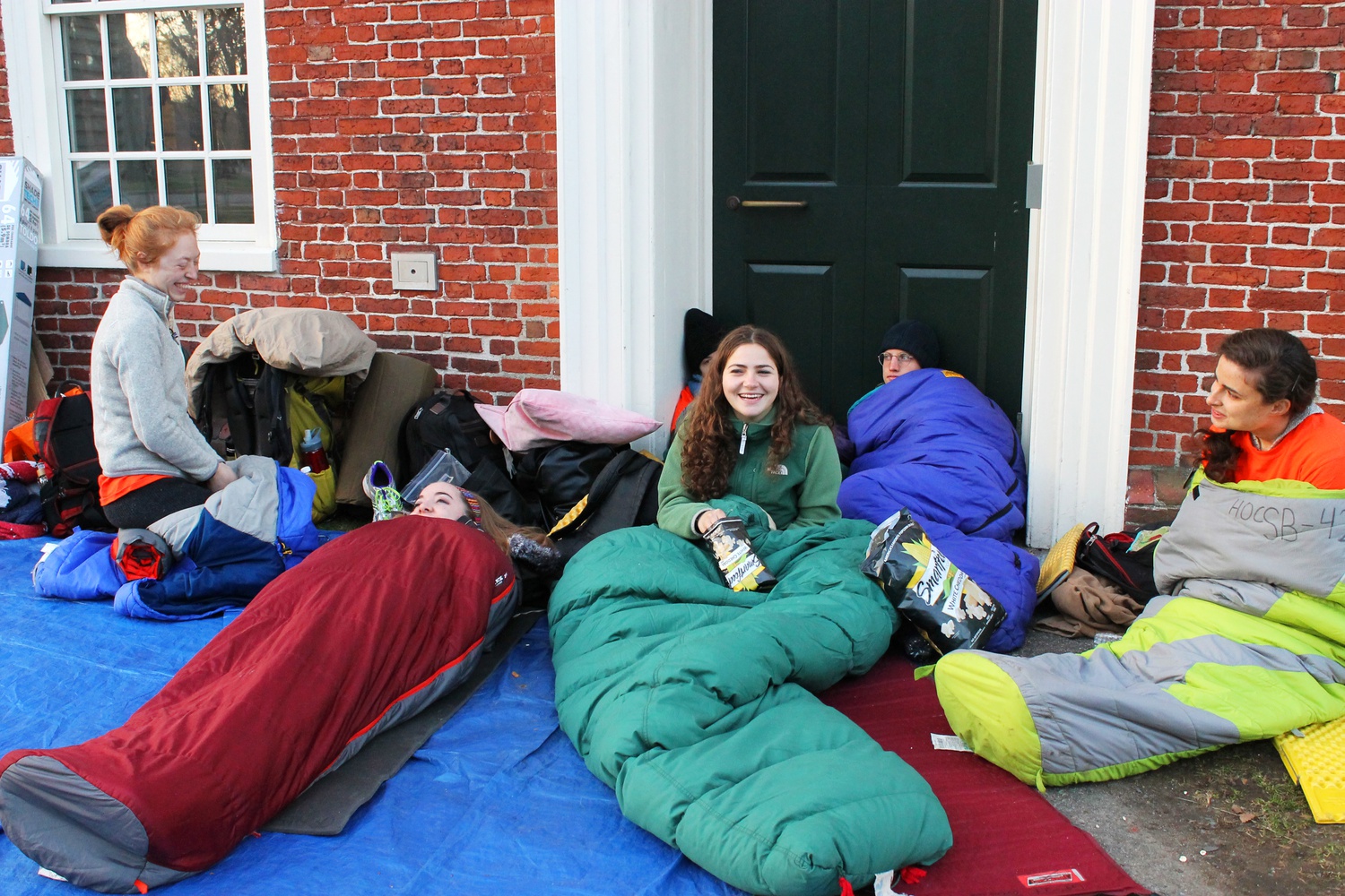 Activists of “Harvard Heat Week” wake up and begin conversations after their first night outside of Massachusetts Hall on Monday morning.