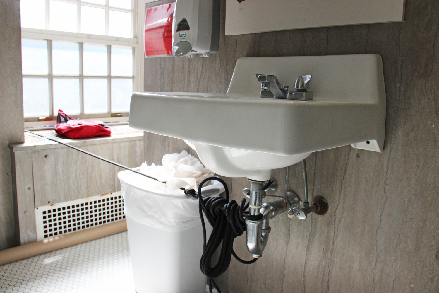 A bathroom sink in Massachusetts Hall serves as an anchor for a Divest Harvard banner outside of the building.