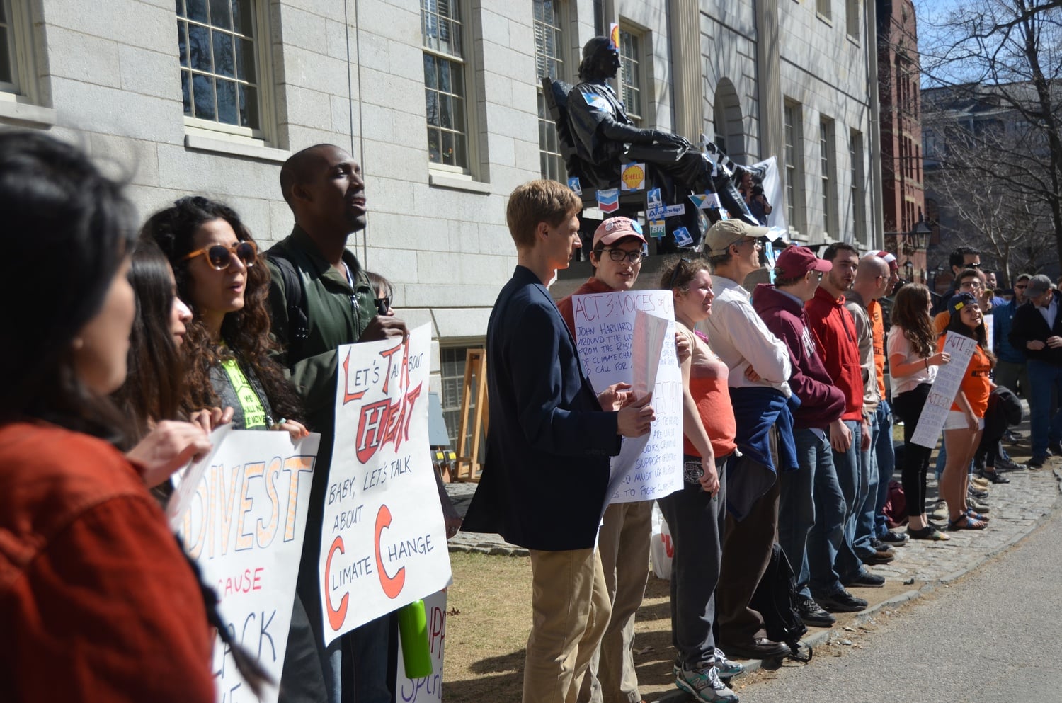 Divest protestors line up around University Hall on Thursday afternoon as part of Harvard Heat Week.