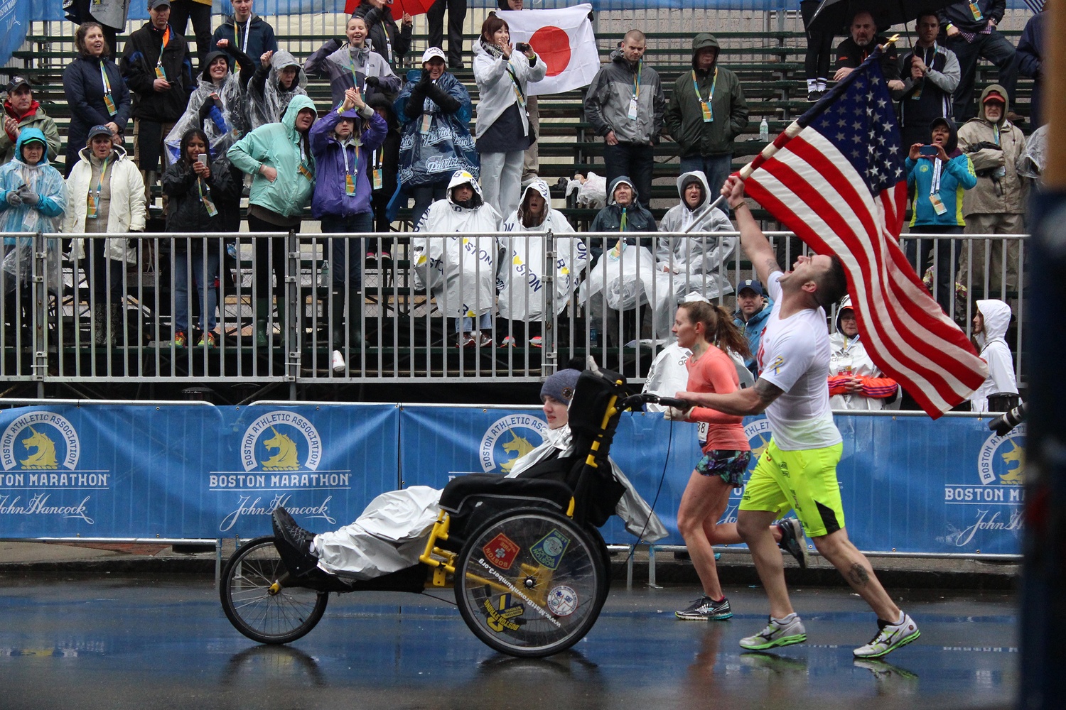 Former Army Ranger Lucas Carr, right, and Stonehill College student Matt Brown, who has been a quadriplegic since he was 15, celebrate as they near the end of the race. The two have run multiple marathons together for charity since 2012.
