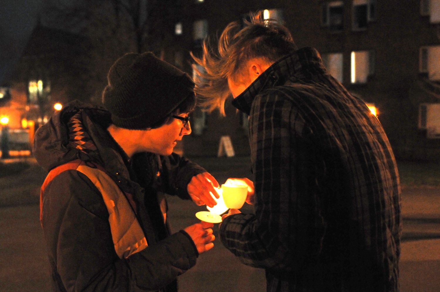 A participant in Thursday's Take Back the Night Vigil reignites a fellow participant's blown out candle before continuing to walk around the Yard.  