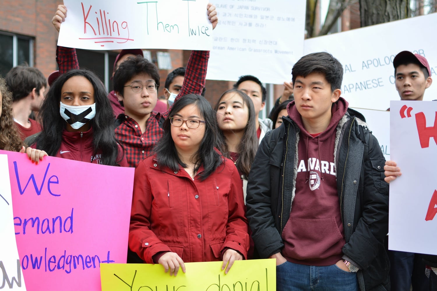 Harvard students hold up signs in protest of views expressed by Japanese Prime Minister Shinzo Abe on the treatment of “comfort women” during World War II. Abe, considered conservative by many, has attempted to play down the role of the Japanese government in wartime human trafficking. 