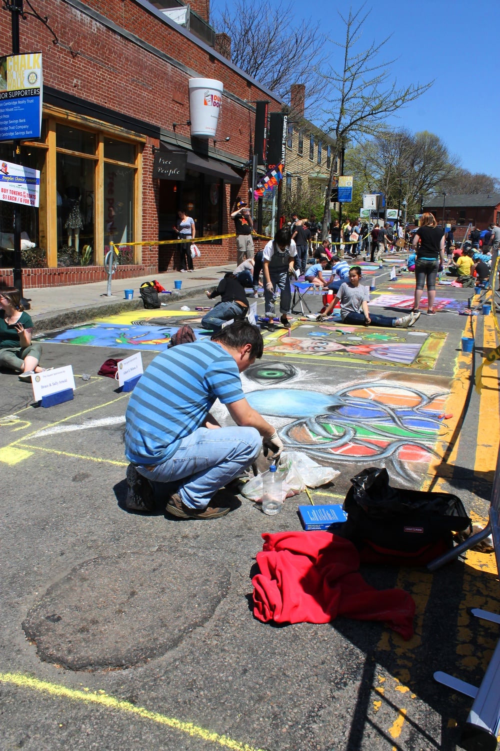 A man kneels over his chalk drawing at the 32nd Annual MayFair in Harvard Square. The Rotary Club of Cambridge’s annual Chalk on the Walk took place on Church St. Sunday.