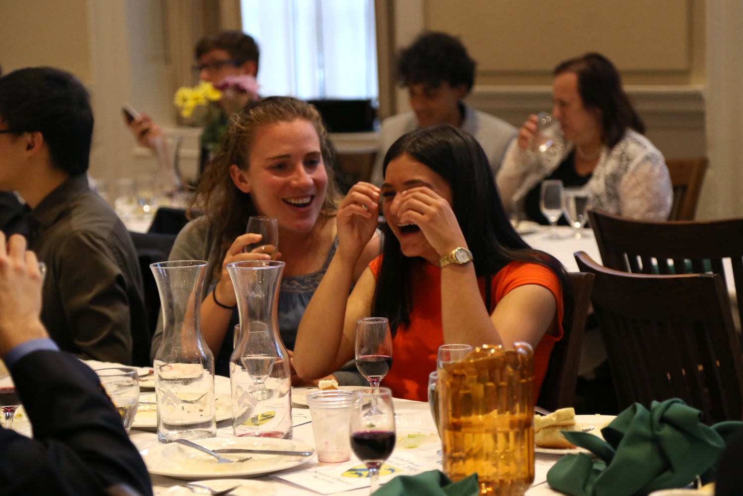 Kelsey S. McKenna '15, right, and inactive Crimson editor Hannah M. Borowsky '15 share a laugh during the Leverett House Senior Dinner on Thursday. The blockmates, who were in the same Freshman Outdoor Program group, met when Orowsky let McKenna store her wallet in her purse. They have been friends ever since.