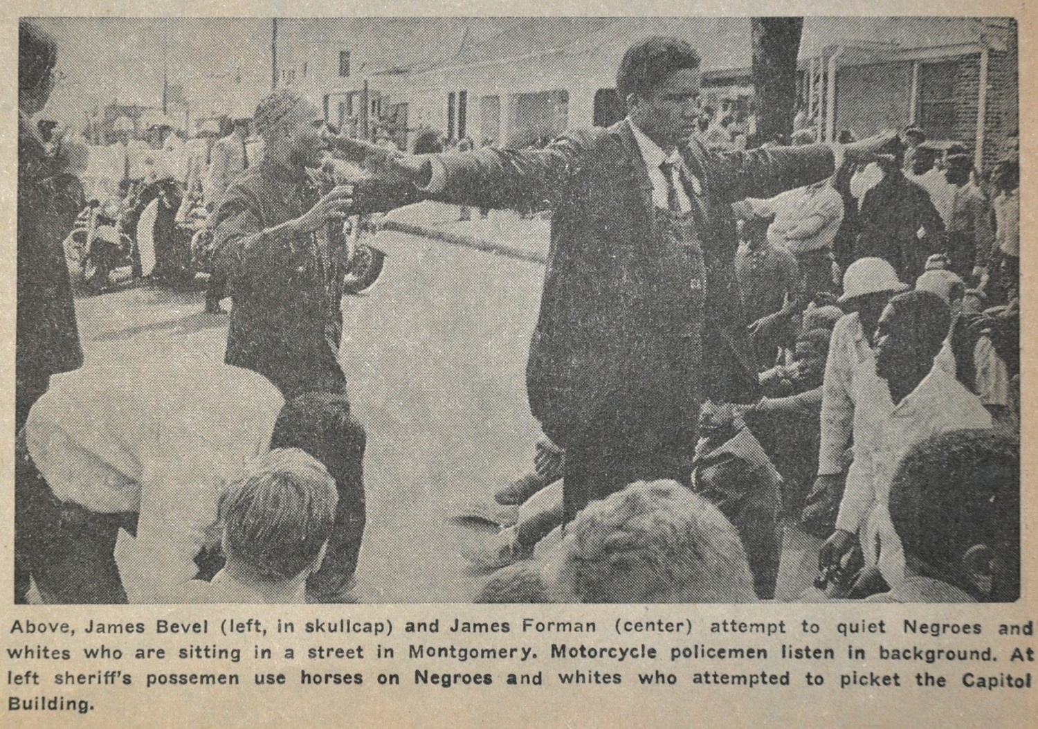 Above, James Bevel (left, in skullcap) and James Forman (center) attempted to calm people sitting in a street in Montgomery, AL. Motorcycle policemen listen in background. At left, sheriff’s possemen use horses to interfere in a picket of the Capitol building.