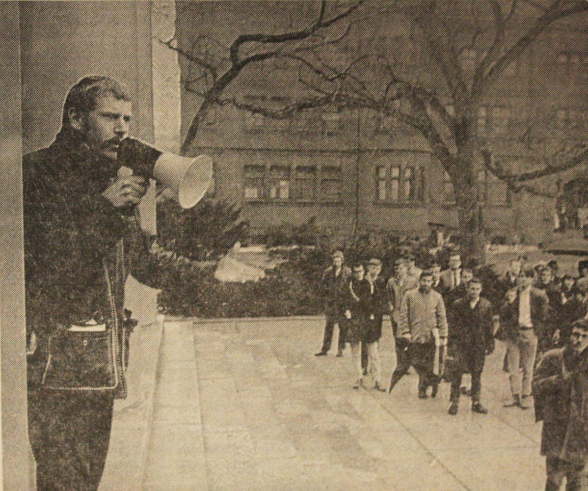 A photograph of Albert Maher '63-2 entreating a mob at Memorial Church appeared in The Crimson on February 13, 1965.