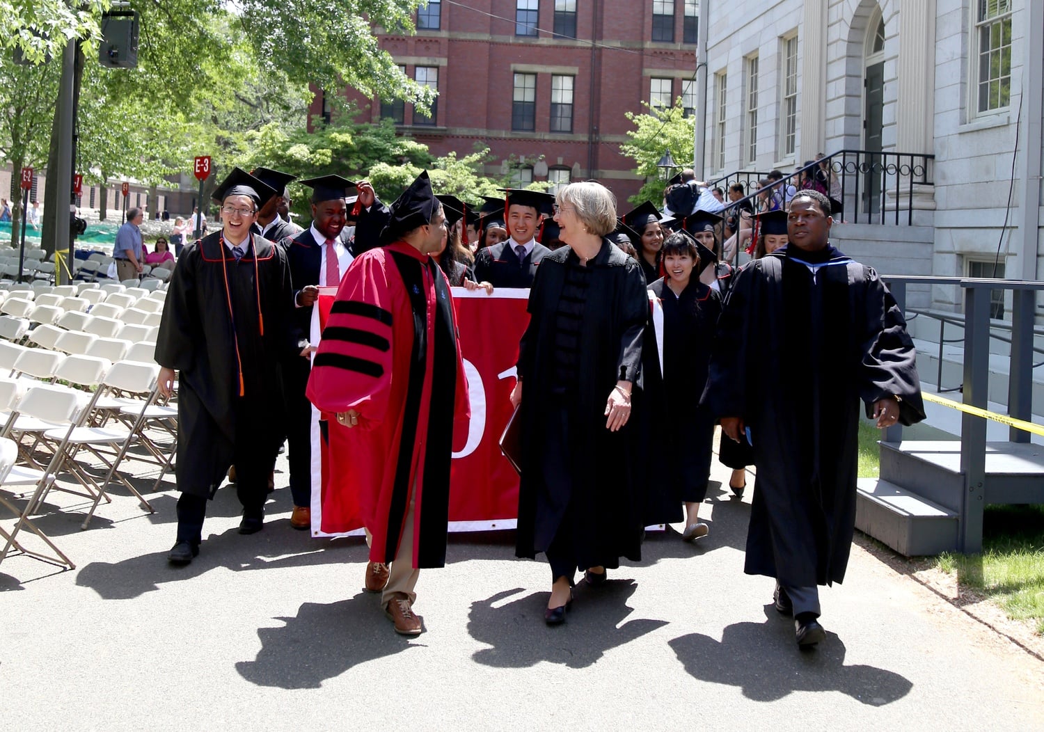 Dean of the College Rakesh Khurana, front left, and University President Drew G. Faust, front center, smile at the 2015 senior class marshals as they lead the Class of 2015 with Reverend Jonathan L. Walton, front right, to Memorial Church for the 2015 Baccalaureate Service on May 26.
