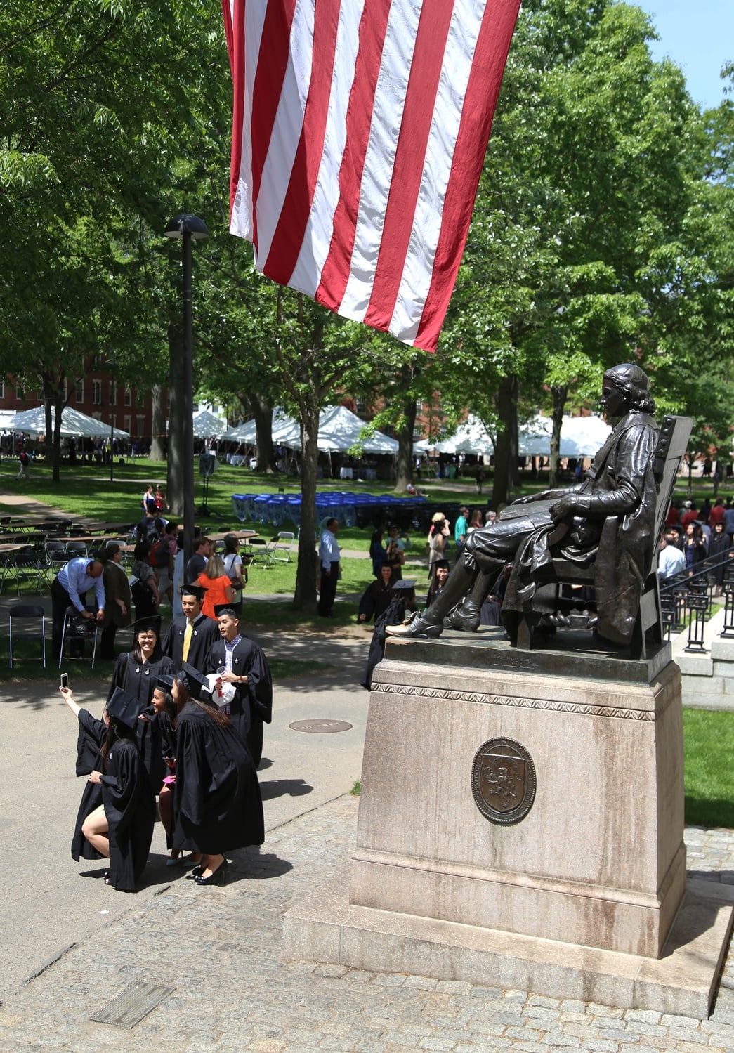 Soon-to-be graduates pose in front of the John Harvard statue before the 2015 Baccalaureate Service.