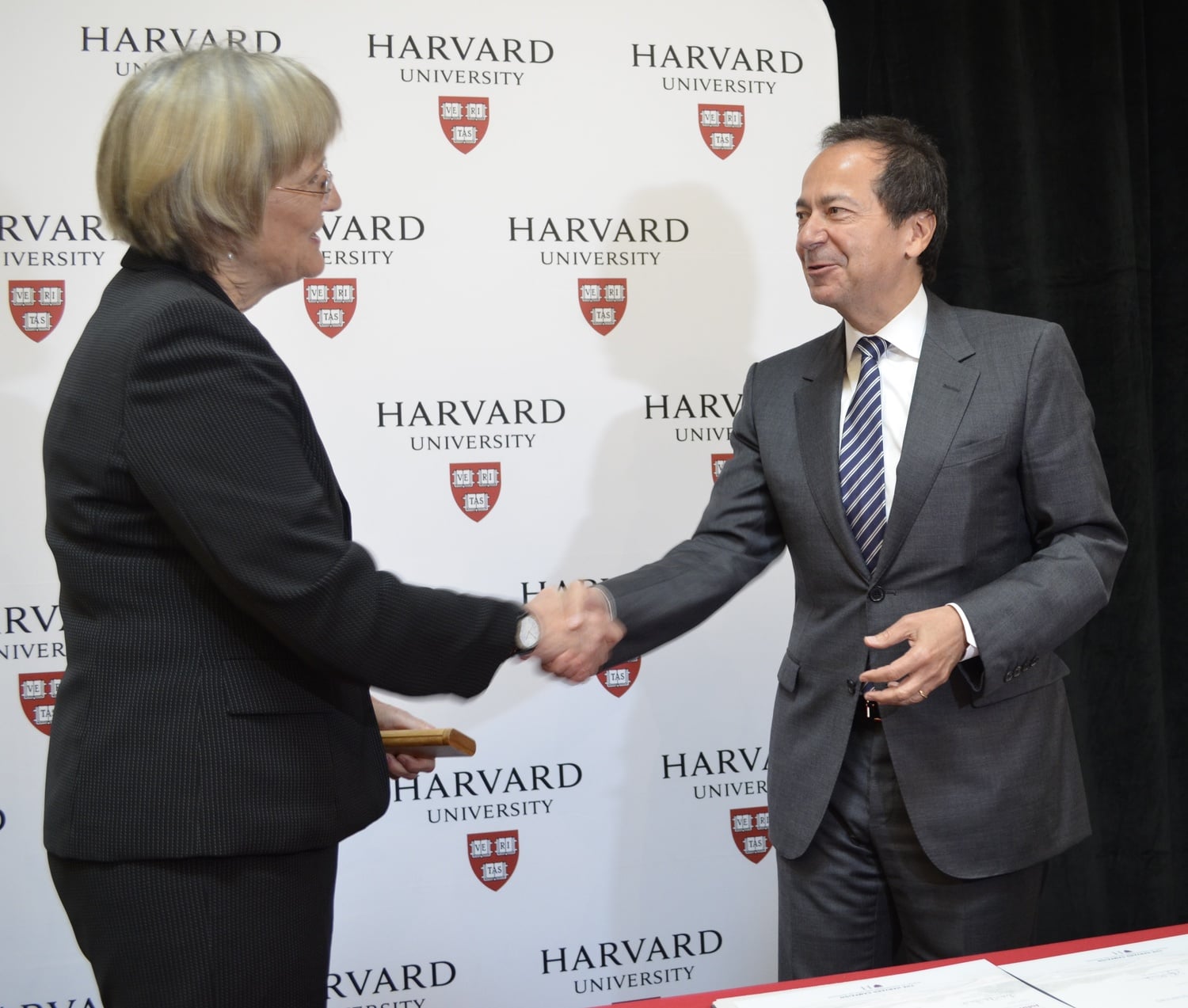 University President Drew G. Faust and hedge fund magnate John A. Paulson shake hands at an event announcing Paulson's $400 million gift to the School of Engineering and Applied Sciences.