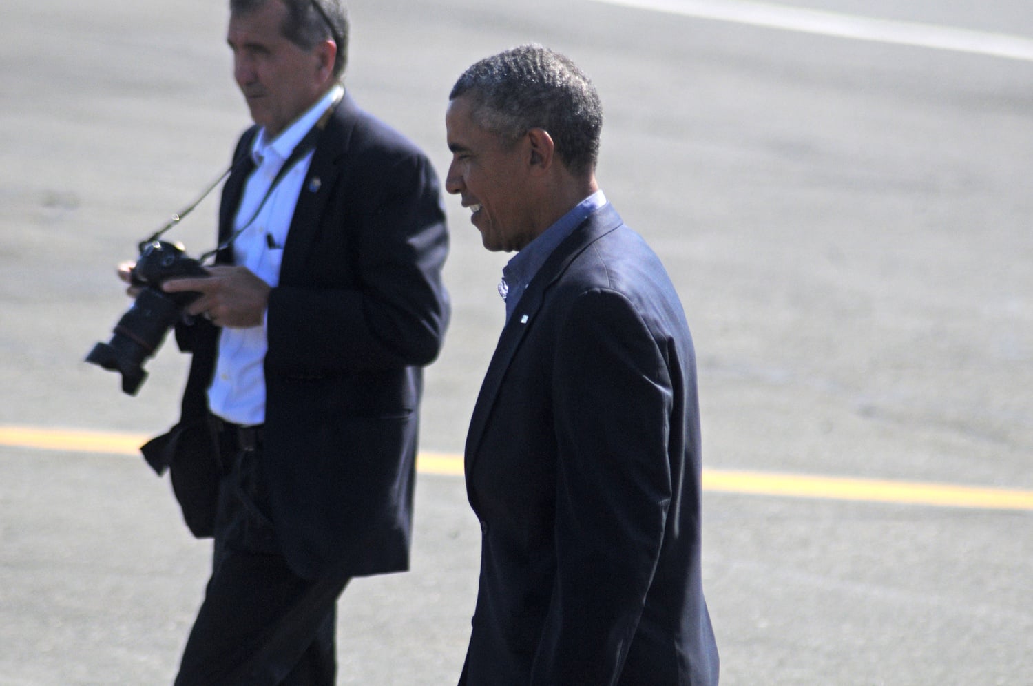 President Barack Obama walks across the tarmac after arriving in Boston on Monday.