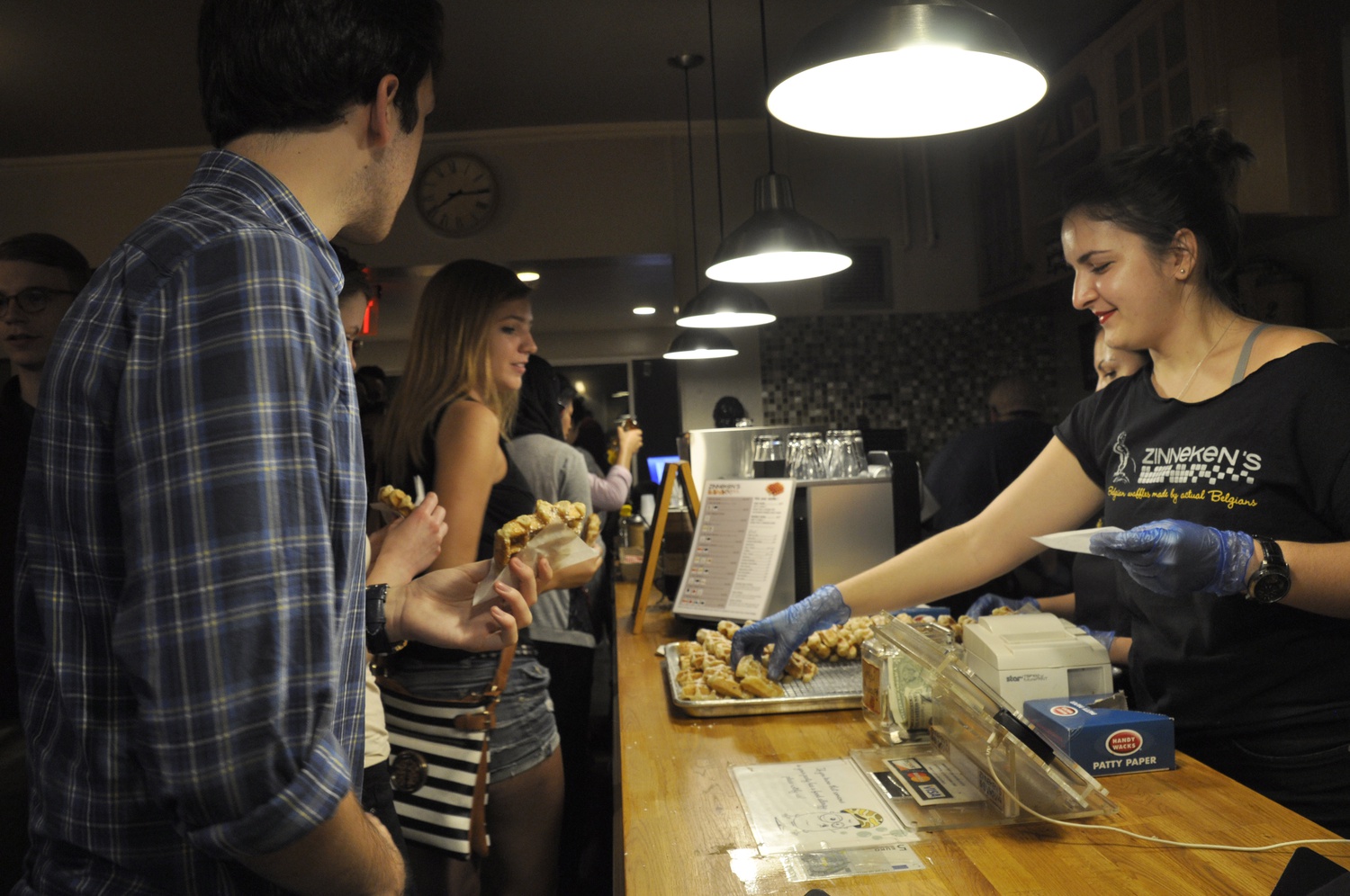 Steven Kunis '17 and Kathryn J. Gunderson '17 enjoy free waffles as part of Zinneken's four-year anniversary event on Tuesday evening. The shop made 800 waffles in preparation for the event, according to a representative.