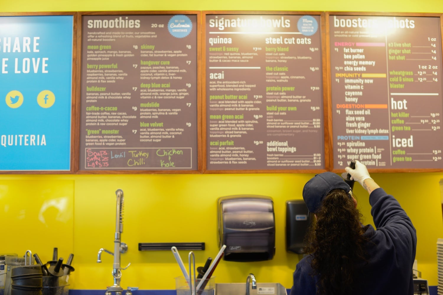 An employee at the Harvard Square Liquiteria prepares a smoothie behind the counter. Liquiteria offers fresh smoothies, cold pressed juices, and prepared foods.