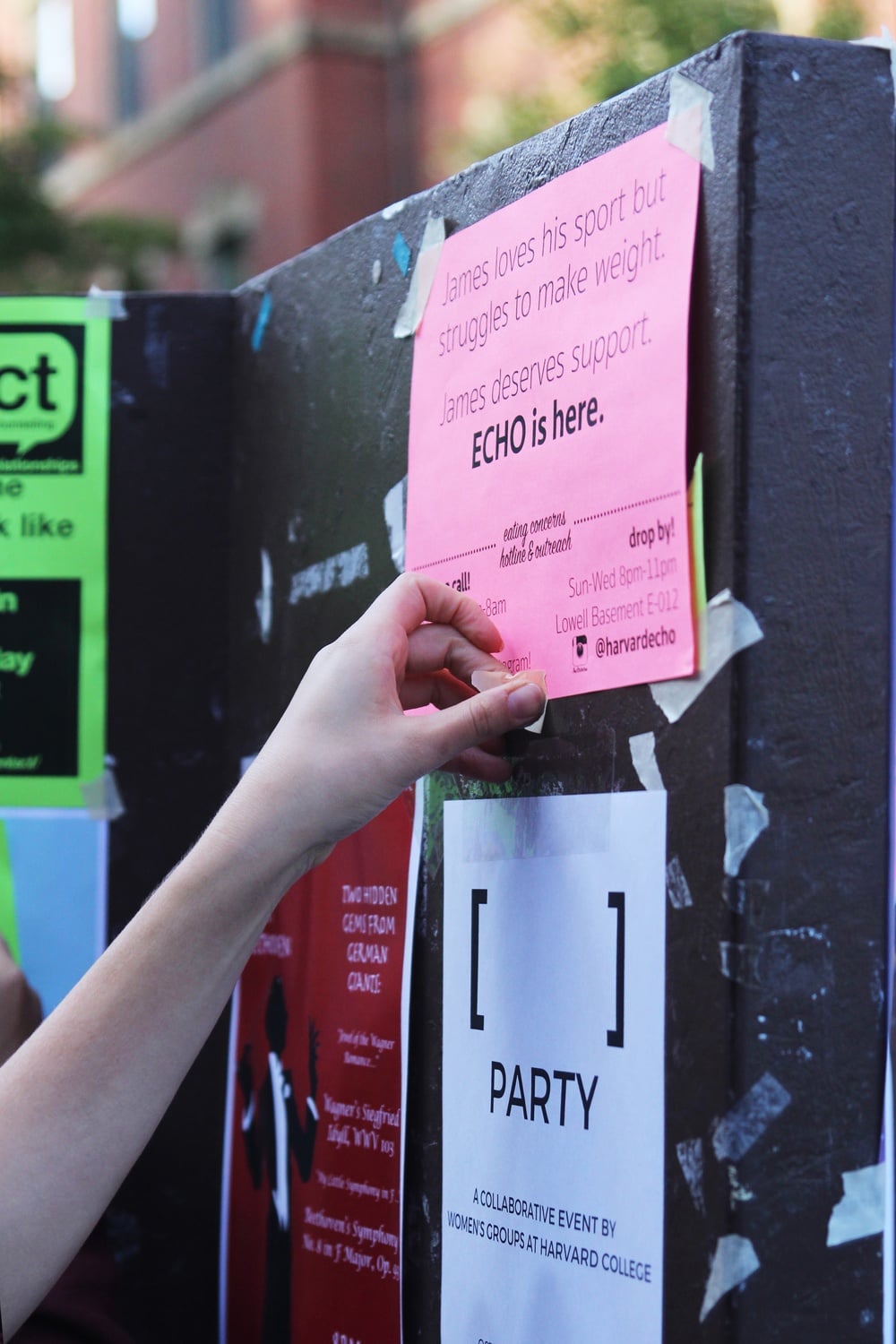 Members of ECHO pin up fliers around the Yard on Monday morning to raise awareness about the mental health resources available on campus. 