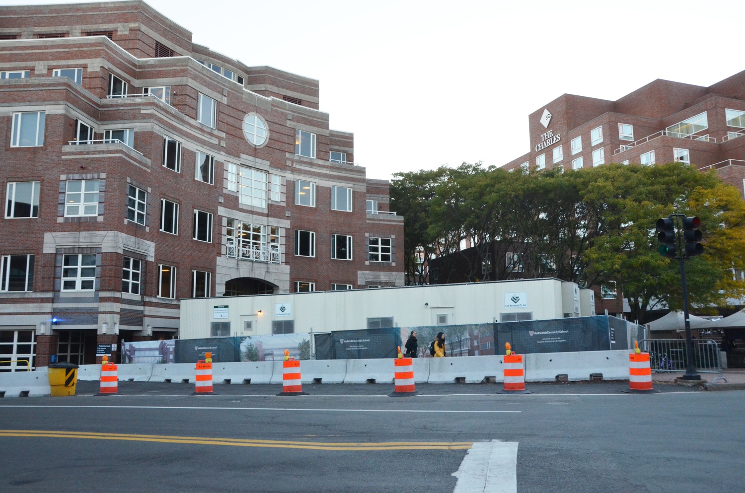Passerby walk by the construction site at the Kennedy School on Monday afternoon.