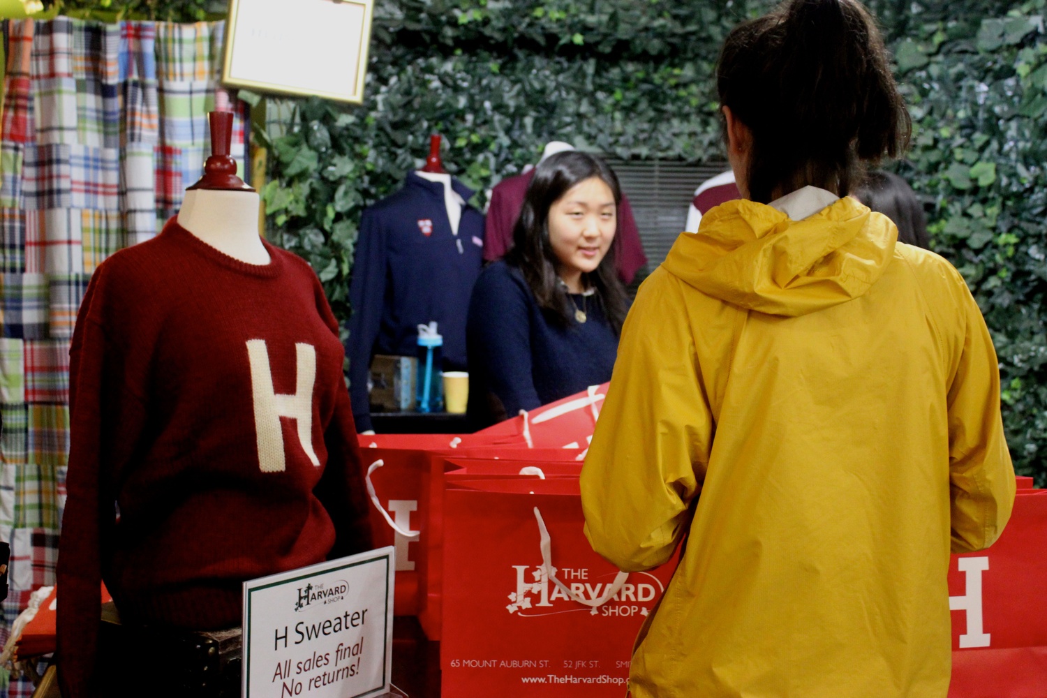 Diana Im ‘17, an employee at HSA’s Harvard Shop, prepares to give a student her H sweater at the sweater’s release party in late September.