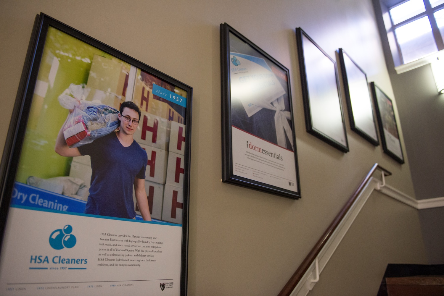 A poster of HSA President Patrick F. Scott ’16 advertises the Cleaners, one of the organization’s various services, and hangs in its office at 67 Mt. Auburn Street. These posters show the services of the agency, in chronological order of their creation.