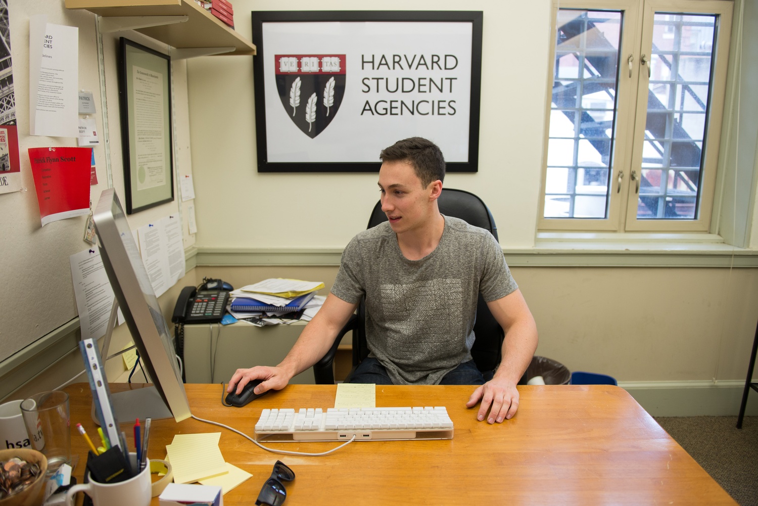Patrick F. Scott ’16, president of Harvard Student Agencies, responds to e-mails in his office in the HSA building. Scott first joined the organization as a laundry deliverer.