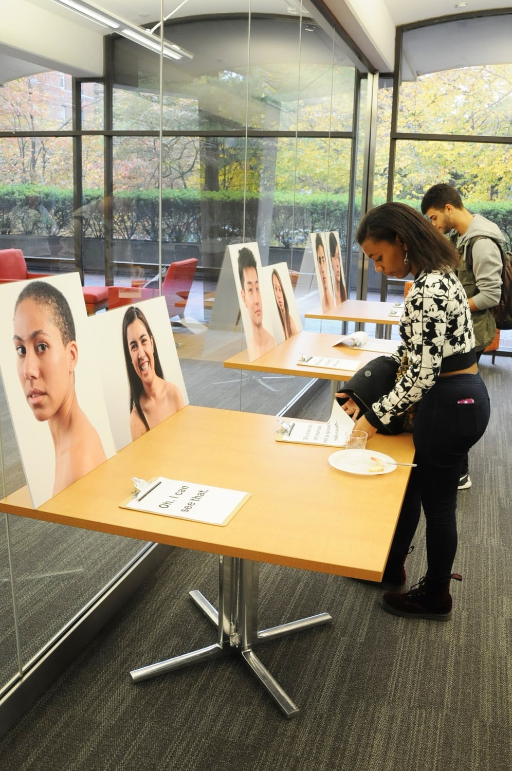 Students study the portraits on display at “OTHER: A Multiracial Student Photo Gallery” at the exhibition’s opening on Sunday afternoon.