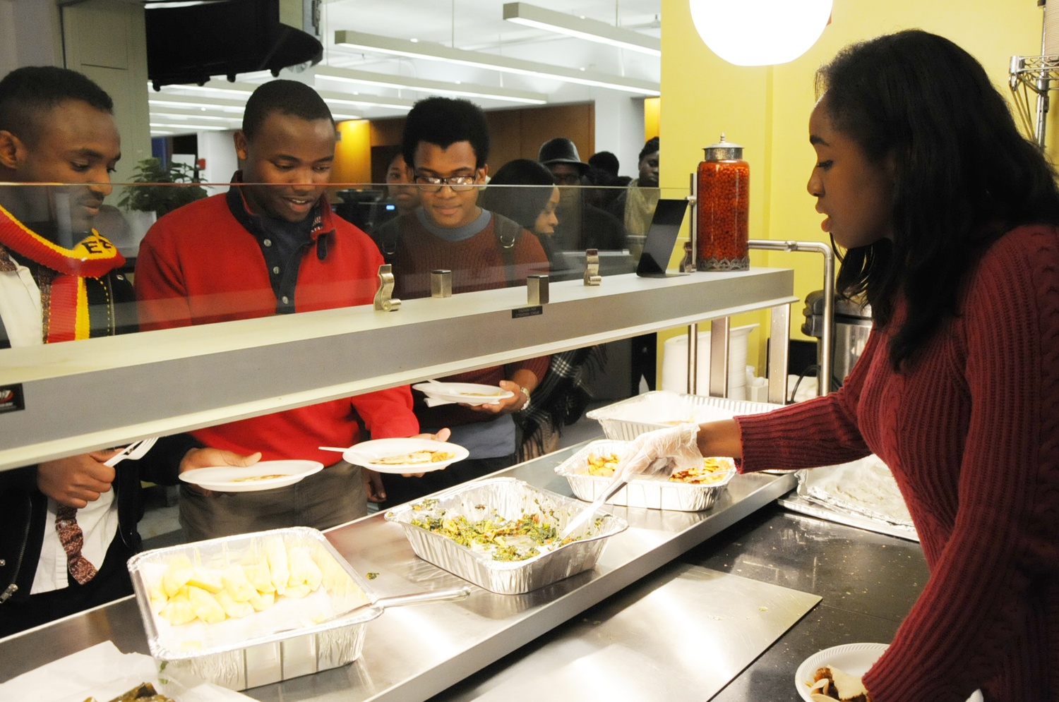 Omolade O. Sogade ’16 (right) serves African cuisine to students at the Harvard African Student Association’s Fall Feast in the Science Center Greenhouse Cafe on Saturday evening.