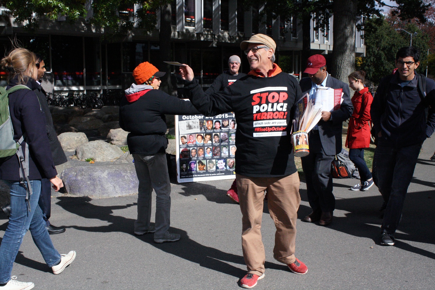 A small group hands out pamphlets in the Science Center Plaza to protest police terror on Friday afternoon.