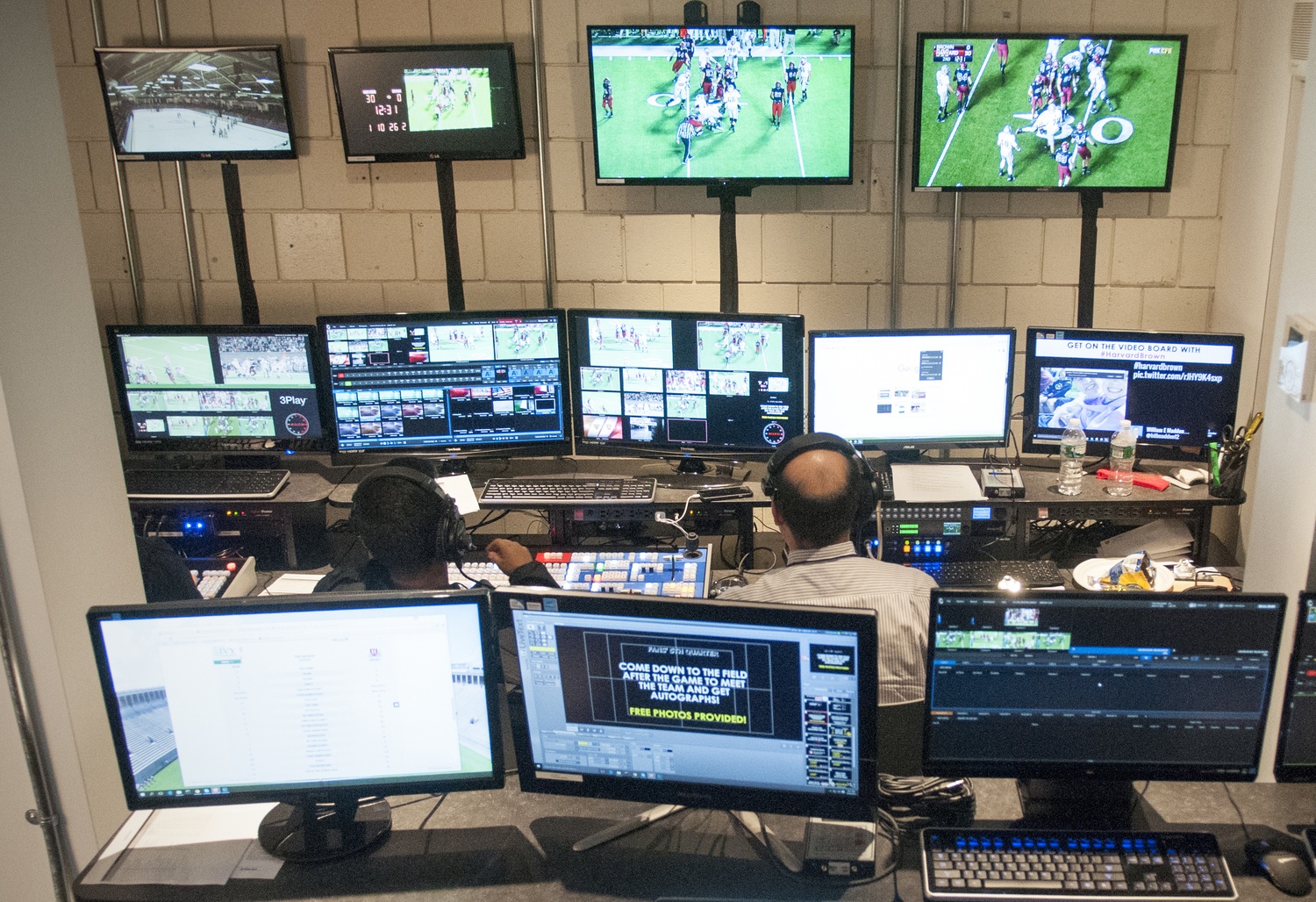 Imry Halevi, right, in the multimedia control room beneath the Bright Hockey Center, monitors cameras as he produces a live stream for the Brown game. Halevi supervises a camera and production crew for each home game, shifting attention between the game production and the stadium’s video board content.