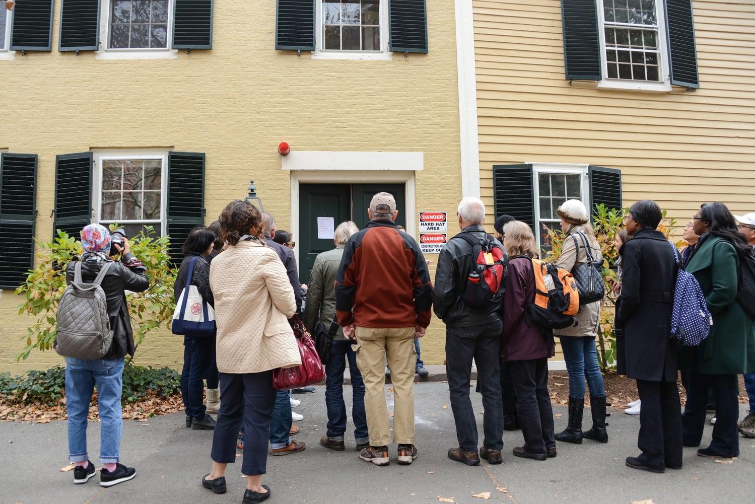 Tourists gather around Wadsworth House as military veteran Specialist J. Holden Gibbons begins a historical military tour of the Harvard campus. 