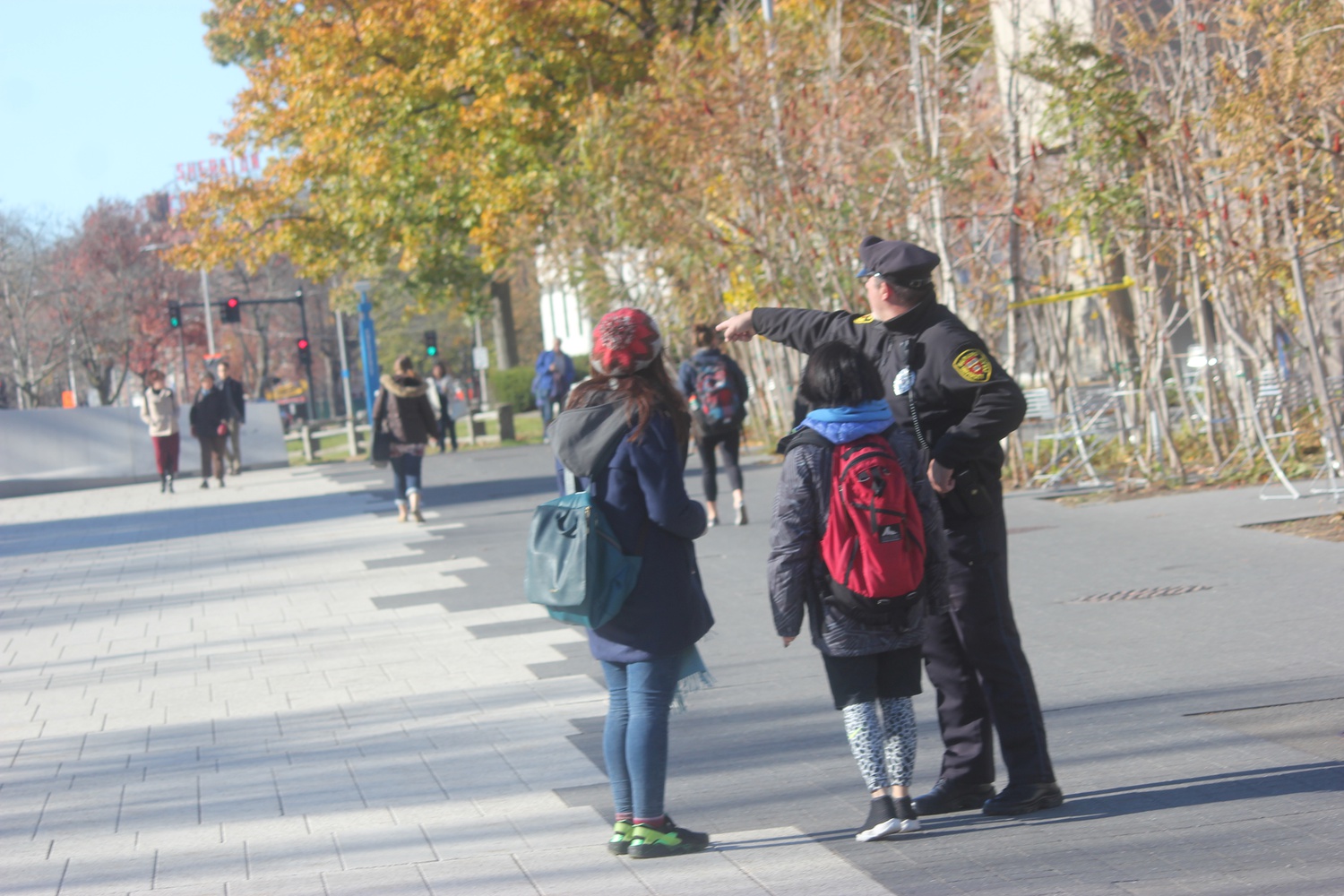 A member of the Harvard University Police Department directs people away from Harvard Yard and the Science Center after students were sent an alert of an unconfirmed bomb threat.